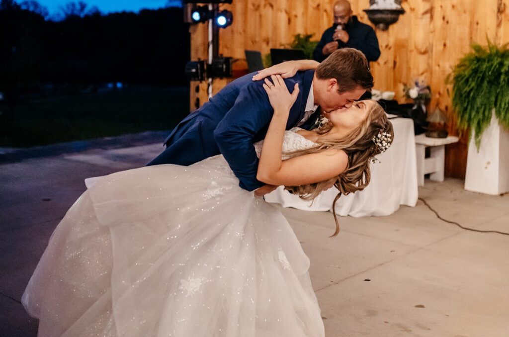 A groom dips the bride for a kiss at their wedding