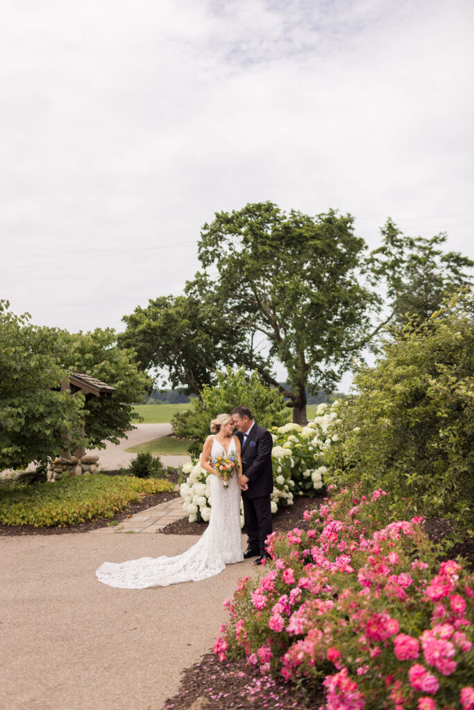 Couple poses for photo on the grounds of Inisfree's estate wedding venue.