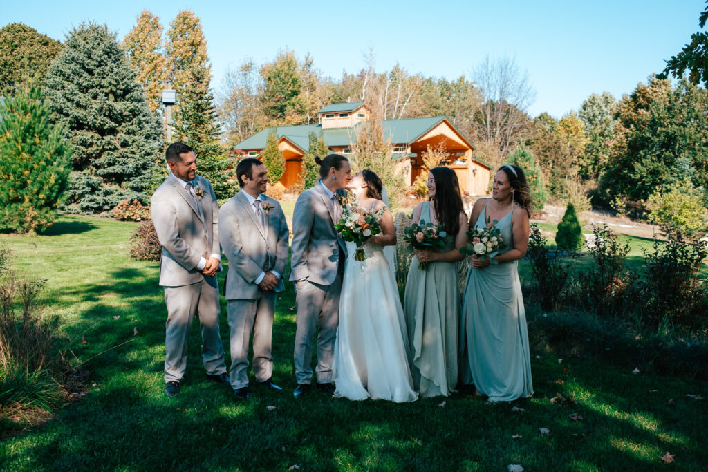 Intimate wedding celebration at Inisfree Estate - couple shares a kiss surrounded by closest friends