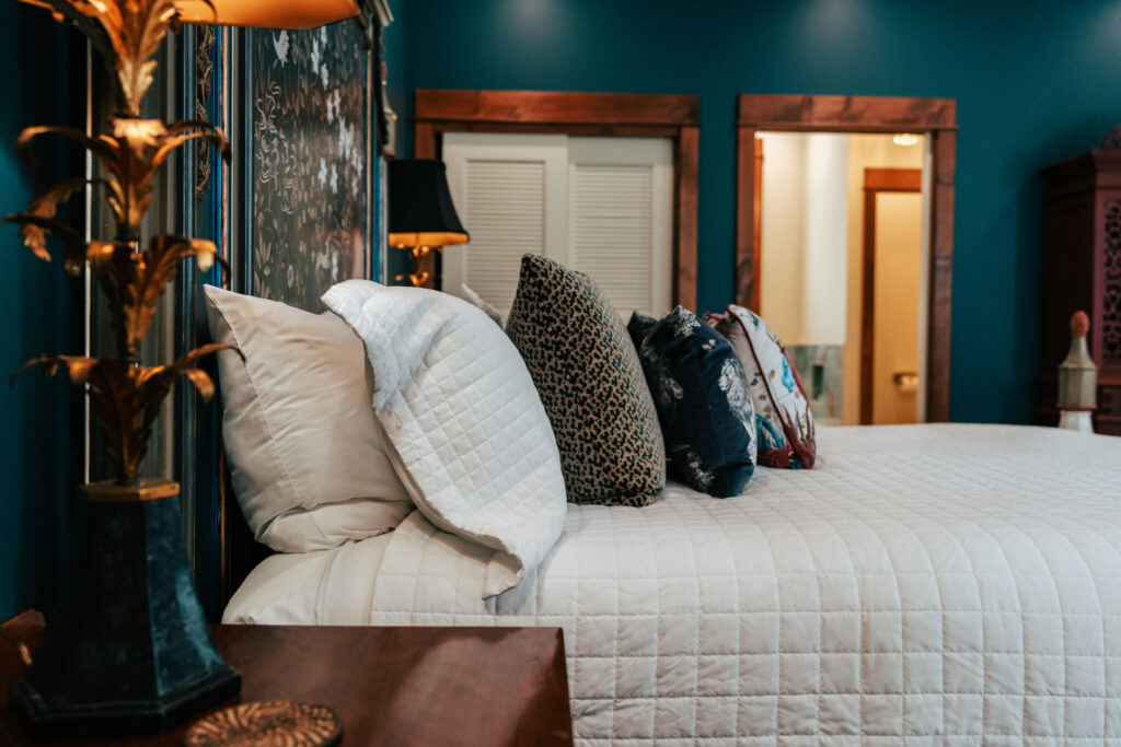 A sideview of a neatly made bed with decorative pillows at Inisfree Estate in Southwest Michigan